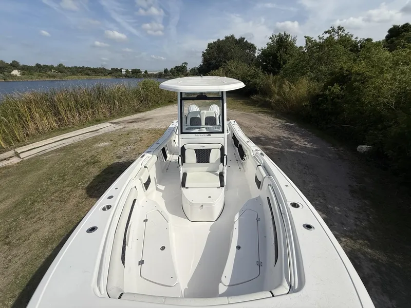 Slide: The Image of 2024 Tidewater 256 CC Adventure boat on a scenic riverside path. - 20