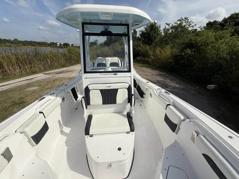 Slide: The Image of 2024 Tidewater 256 CC Adventure boat, spacious interior, white seating, outdoor setting. - 21