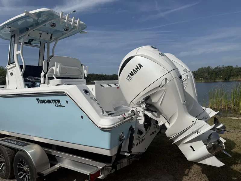 Slide: The Image of 2024 Tidewater 256 CC Adventure boat with Yamaha engine, parked near a lake. - 6