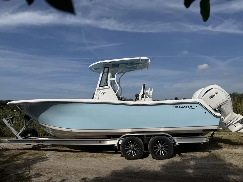 Slide: The Image of 2024 Tidewater 256 CC Adventure boat on trailer, featuring Yamaha engine, under clear blue sky. - 7