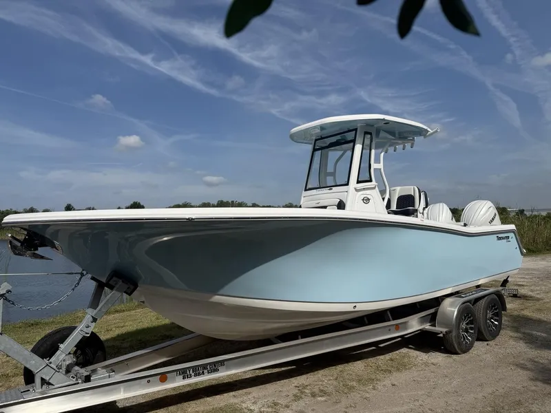 Slide: The Image of 2024 Tidewater 256 CC Adventure boat on trailer under clear blue sky. - 8