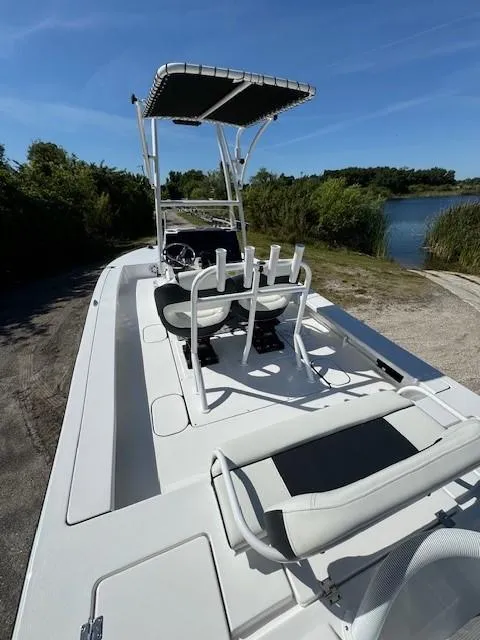 Slide: The Image of 2024 Tidewater 23 TPC RAPTOR boat with T-top, docked near a serene lake. - 15