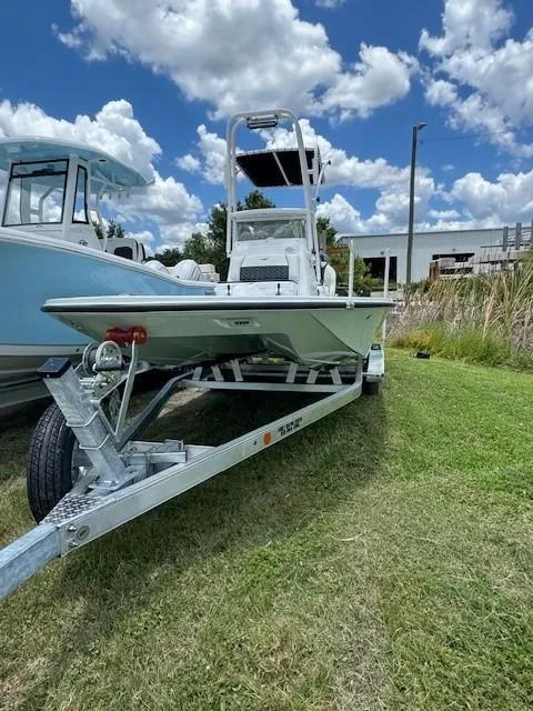 Slide: The Image of 2024 Tidewater 23 TPC RAPTOR boat on a trailer, parked on grass under a blue sky. - 17
