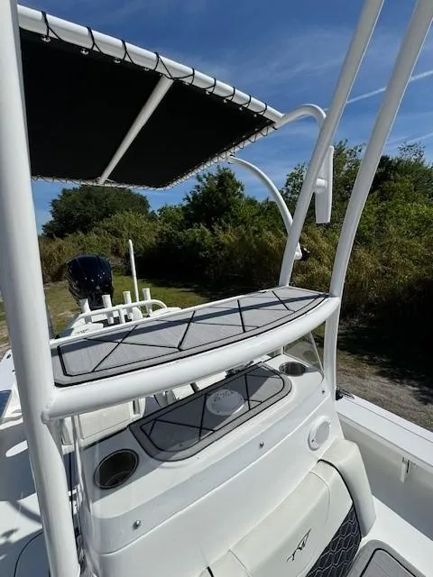 Slide: The Image of 2024 Tidewater 23 TPC RAPTOR boat with T-top and console, docked outdoors. - 4