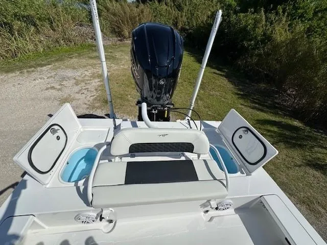 Slide: The Image of 2024 Tidewater 23 TPC RAPTOR boat with open storage compartments and outboard motor. - 9