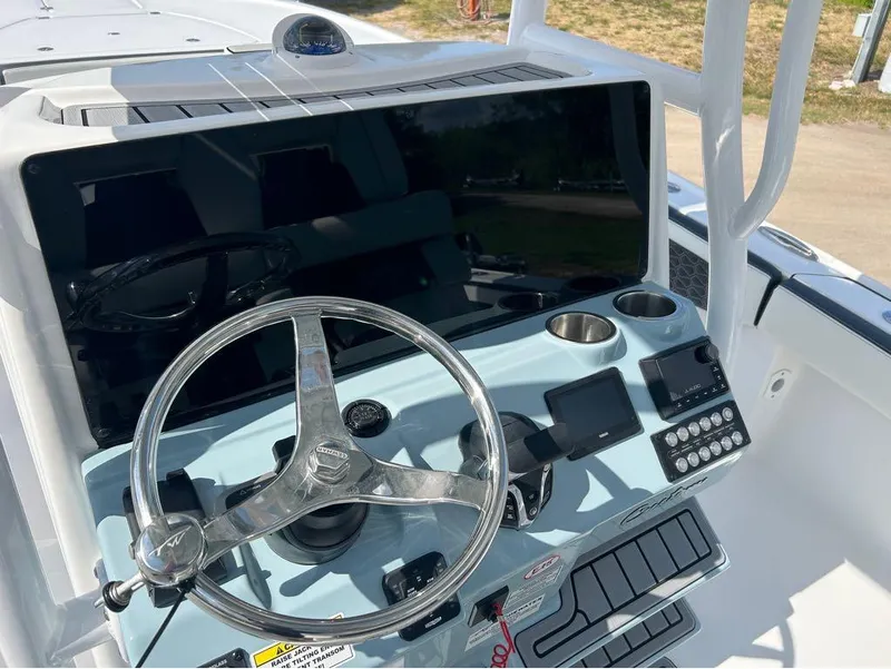 Slide: The Image of Control panel of the 2025 Tidewater 2700 Carolina Bay boat with steering wheel and electronics. - 6