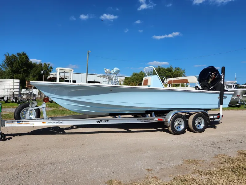 Slide: The Image of 2024 Hewes 21 REDFISHER boat on trailer under clear blue sky. - 1