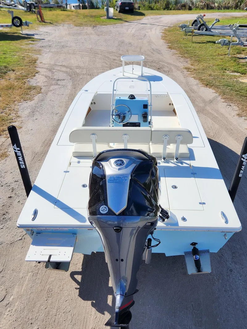Slide: The Image of 2024 Hewes 21 REDFISHER boat with Yamaha 250 engine on a dirt path. - 2