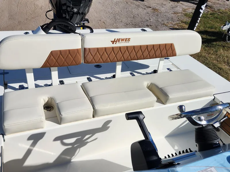 Slide: The Image of 2024 Hewes 21 REDFISHER boat interior with cushioned seating and steering console. - 5