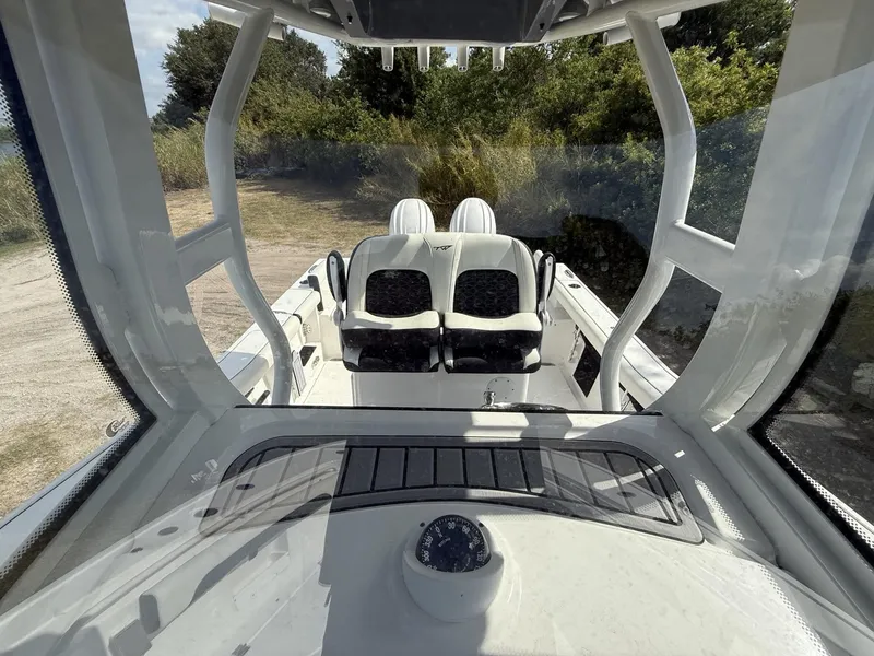 Slide: The Image of 2024 Tidewater 256 LXF boat interior with dual seats and dashboard view. - 11