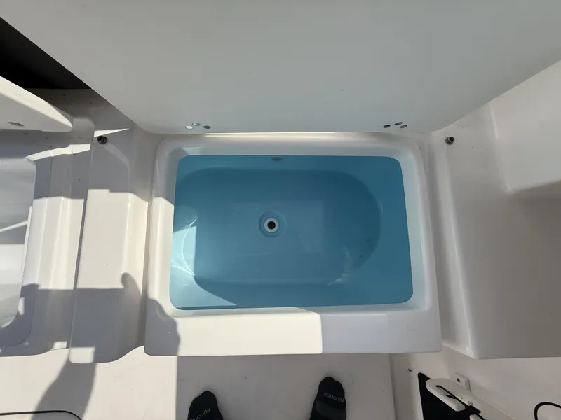 Slide: The Image of 2024 Tidewater 256 LXF boat interior with a blue livewell. - 13