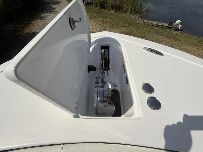 Slide: The Image of 2024 Tidewater 256 LXF boat anchor compartment open by the water. - 23