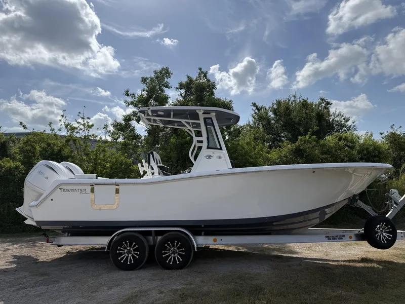 Slide: The Image of 2024 Tidewater 256 LXF boat on trailer under a partly cloudy sky. - 3