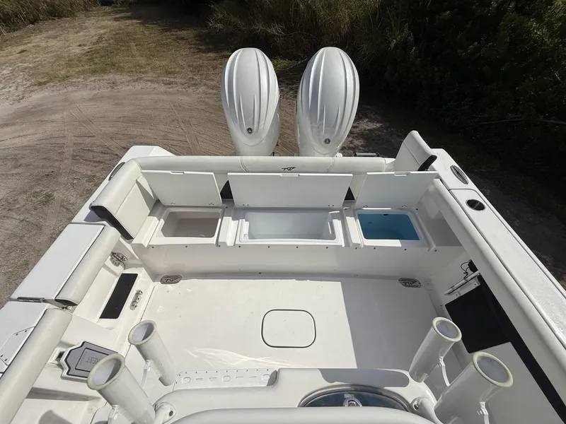Slide: The Image of 2024 Tidewater 256 LXF boat deck with dual engines and storage compartments. - 39