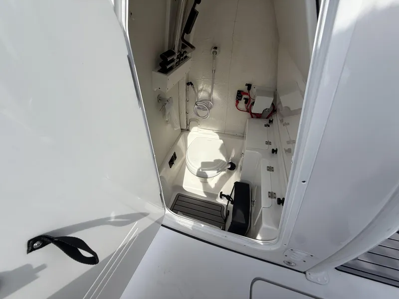 Slide: The Image of 2024 Tidewater 256 LXF boat interior cabin with toilet and storage compartments. - 48