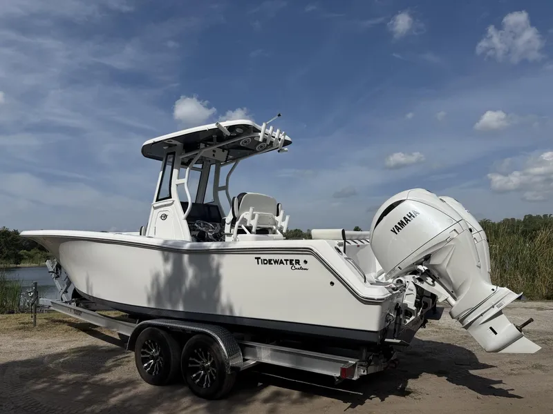 Slide: The Image of 2024 Tidewater 256 LXF boat on trailer with Yamaha engine, under a clear blue sky. - 6
