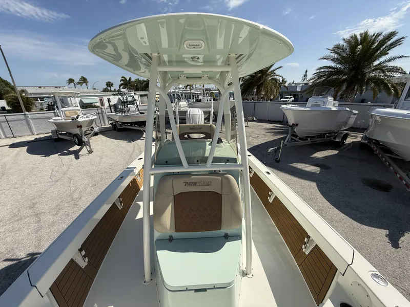 Slide: The Image of 2024 Pathfinder 2600 TRS boat with T-top, parked outdoors under clear sky. - 12