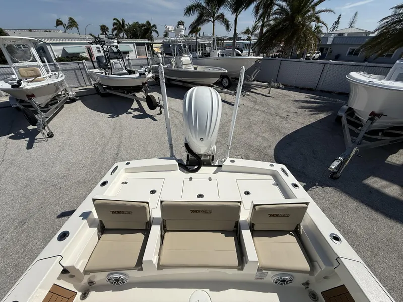 Slide: The Image of 2024 Pathfinder 2600 TRS boat with seating, outboard motor, and surrounding boats in a marina. - 16