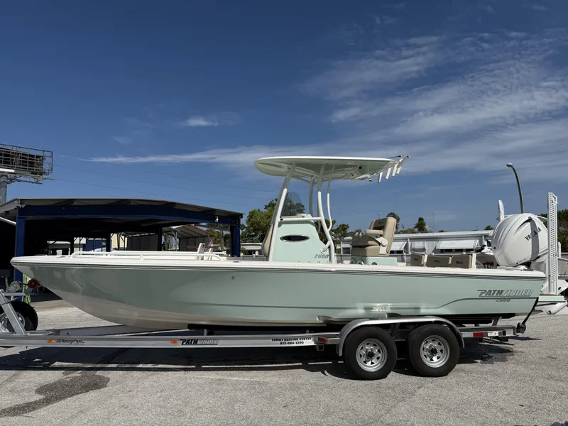 Slide: The Image of 2024 Pathfinder 2600 TRS boat on trailer under clear blue sky. - 2