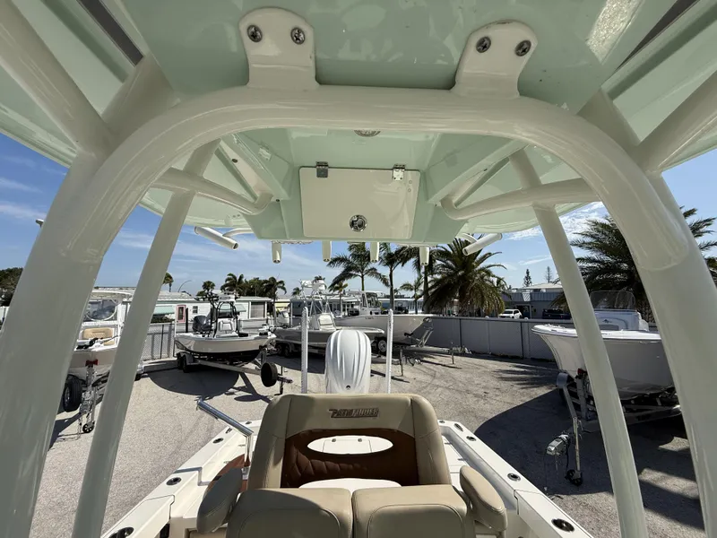 Slide: The Image of 2024 Pathfinder 2600 TRS boat interior with T-top, docked under clear sky. - 23
