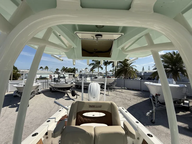 Slide: The Image of 2024 Pathfinder 2600 TRS boat interior with helm, surrounded by other boats and palm trees. - 24