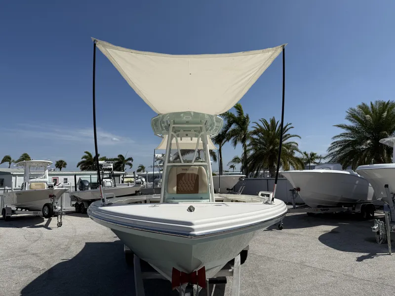 Slide: The Image of 2024 Pathfinder 2600 TRS boat with canopy, parked outdoors under clear blue sky. - 26