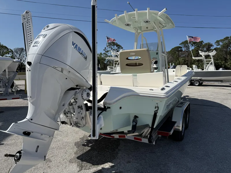 Slide: The Image of 2024 Pathfinder 2600 TRS boat with Yamaha engine, parked on a trailer, American flags in background. - 4