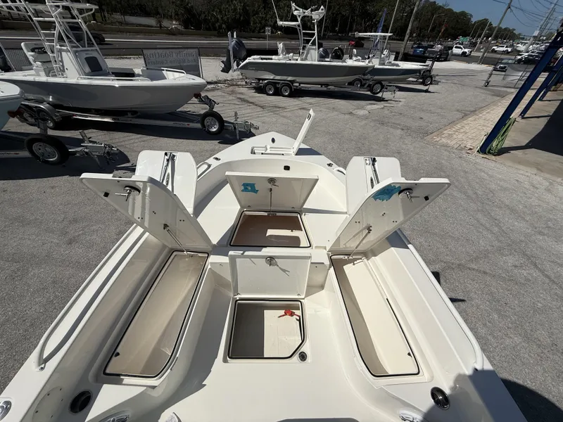 Slide: The Image of 2024 Pathfinder 2600 TRS boat with open storage compartments, parked on a trailer. - 48