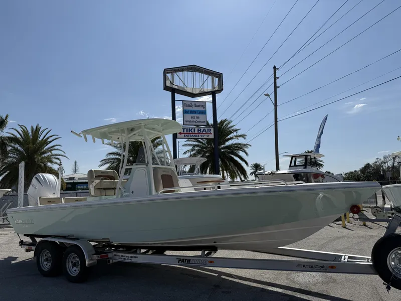 Slide: The Image of 2024 Pathfinder 2600 TRS boat on trailer, parked near palm trees and signage. - 6