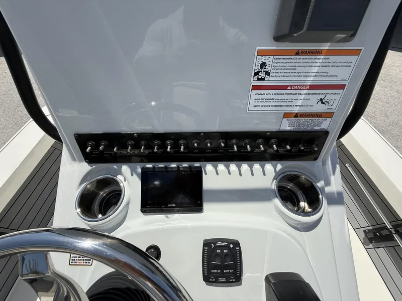 Slide: The Image of 2024 Pathfinder 2300 HPS boat dashboard with controls, switches, and warning labels. - 11