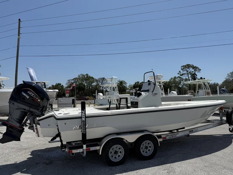 Slide: The Image of 2024 Pathfinder 2300 HPS boat on trailer with Yamaha engine, parked outdoors. - 2
