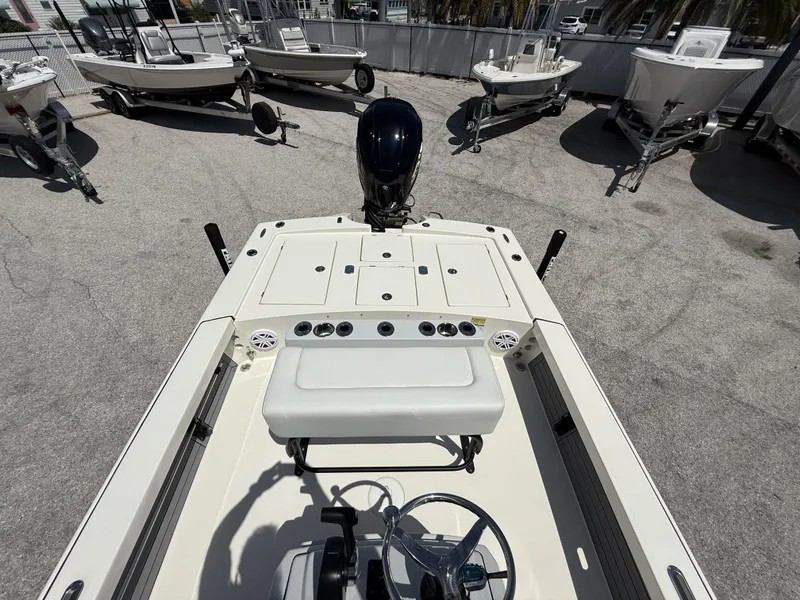 Slide: The Image of 2024 Pathfinder 2300 HPS boat interior with steering wheel and seating, displayed outdoors. - 28