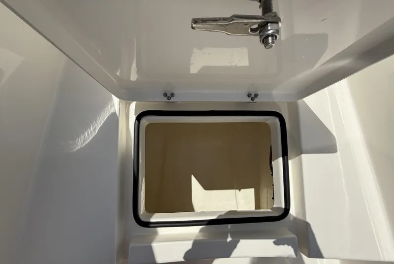 Slide: The Image of Open storage compartment on 2024 Pathfinder 2300 HPS boat, featuring a secure latch. - 31