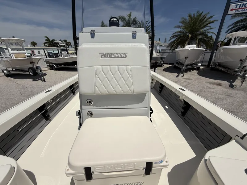 Slide: The Image of 2024 Pathfinder 2300 HPS boat interior with white seating and palm trees in the background. - 34