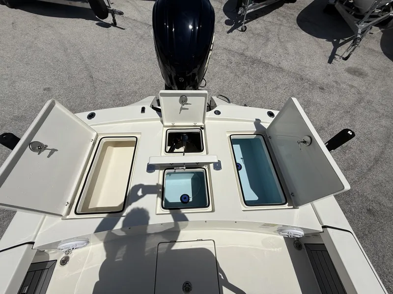 Slide: The Image of 2024 Pathfinder 2300 HPS boat deck with open storage compartments and engine view. - 37