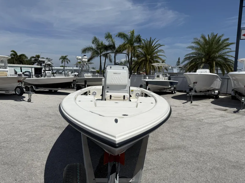 Slide: The Image of 2024 Pathfinder 2300 HPS boat on trailer, surrounded by palm trees and other boats. - 7