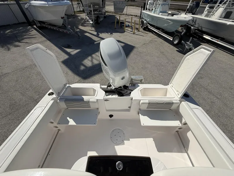 Slide: The Image of 2024 Aquasport 2300 CC boat interior with open storage compartments and outboard motor. - 10