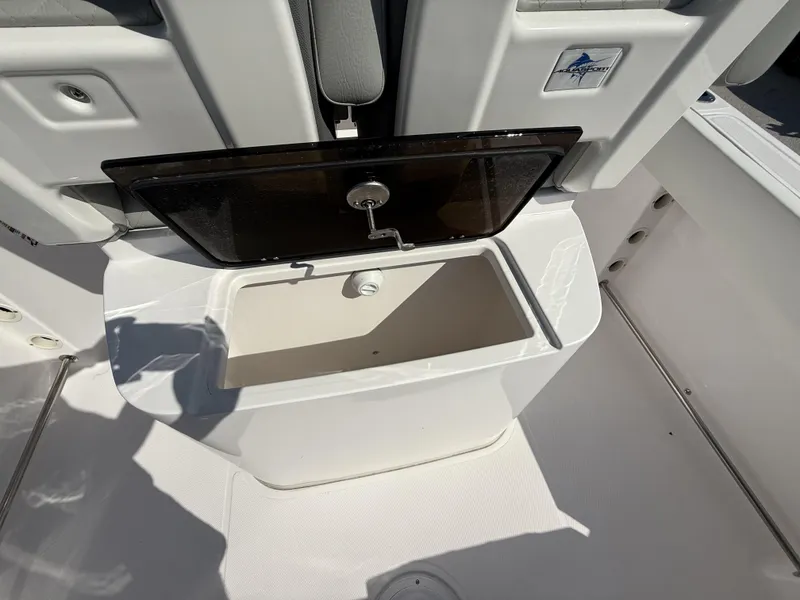 Slide: The Image of 2024 Aquasport 2300 CC boat storage compartment with open lid, showcasing interior space. - 11