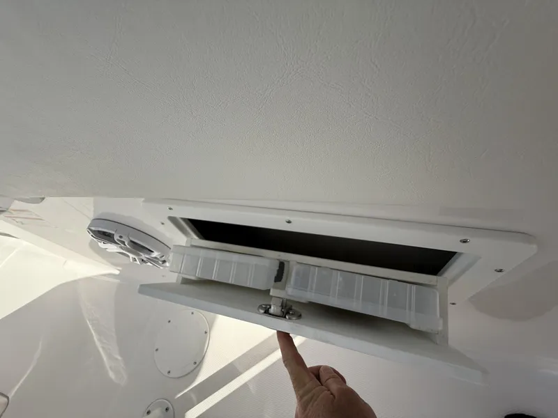 Slide: The Image of 2024 Aquasport 2300 CC boat storage compartment with organizer trays. - 16