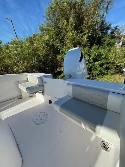 Slide: The Image of 2024 Aquasport 2300 CC boat interior with seating and outboard motor. - 17