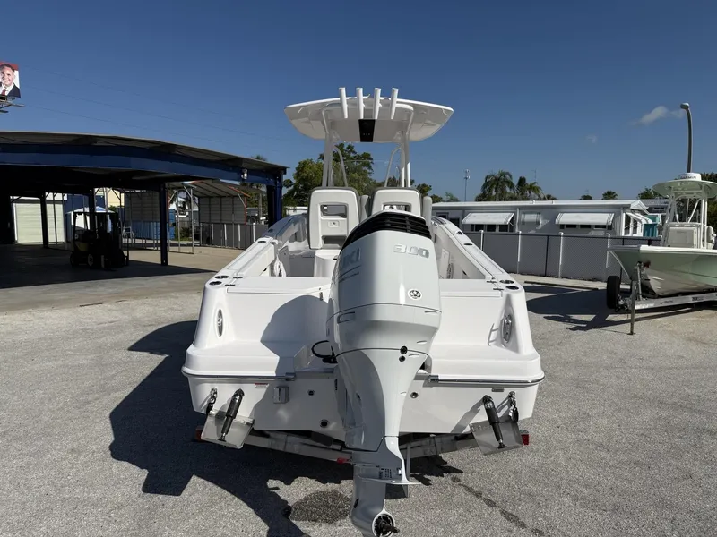 Slide: The Image of 2024 Aquasport 2300 CC boat with powerful outboard motor, parked outdoors on a sunny day. - 19