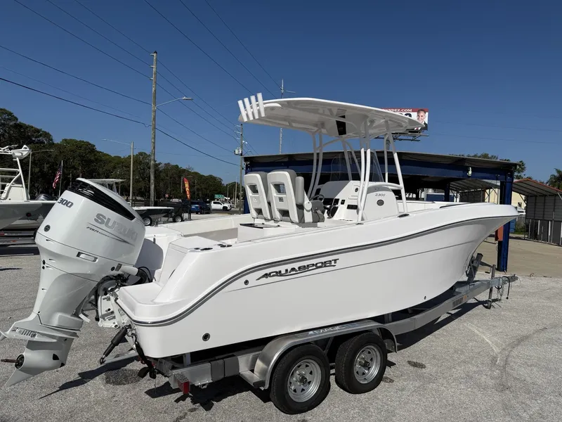 Slide: The Image of 2024 Aquasport 2300 CC boat on trailer with Suzuki outboard motor. - 22