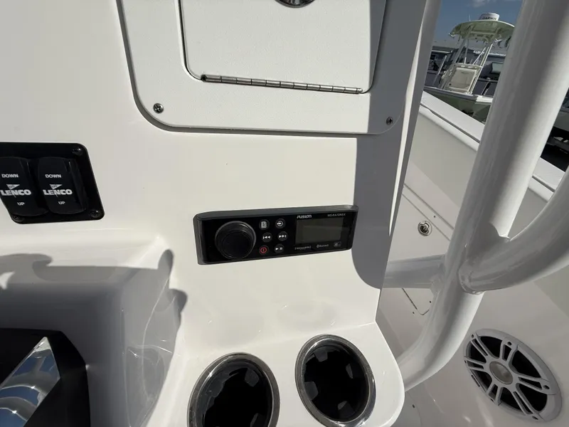 Slide: The Image of 2024 Aquasport 2300 CC boat console with controls, cup holders, and audio system. - 28