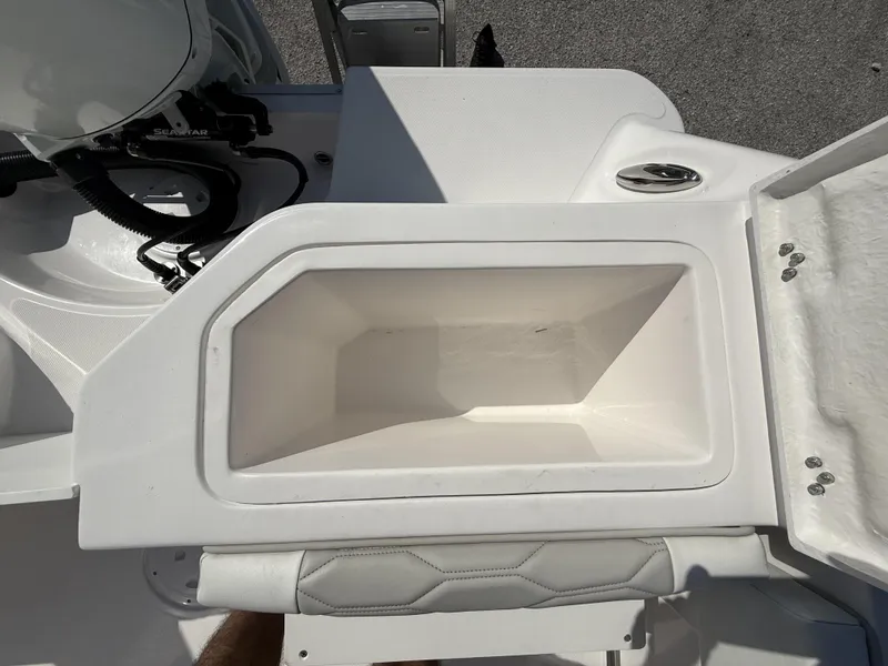 Slide: The Image of 2024 Aquasport 2300 CC boat storage compartment, open lid, white interior, and sleek design. - 34