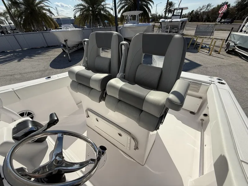 Slide: The Image of 2024 Aquasport 2300 CC boat interior with dual seats and steering wheel. - 35