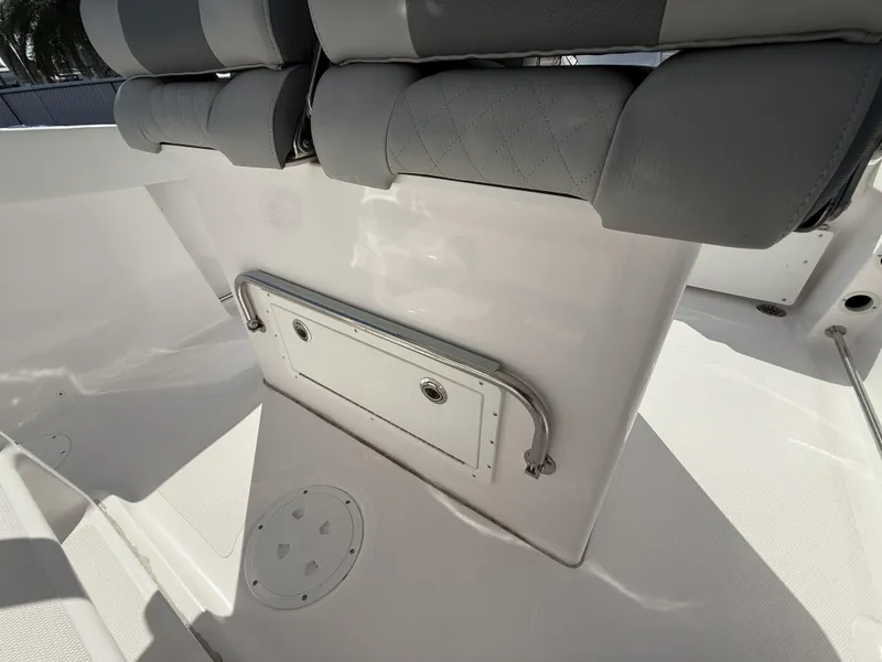 Slide: The Image of 2024 Aquasport 2300 CC boat interior with cushioned seating and storage compartment. - 36