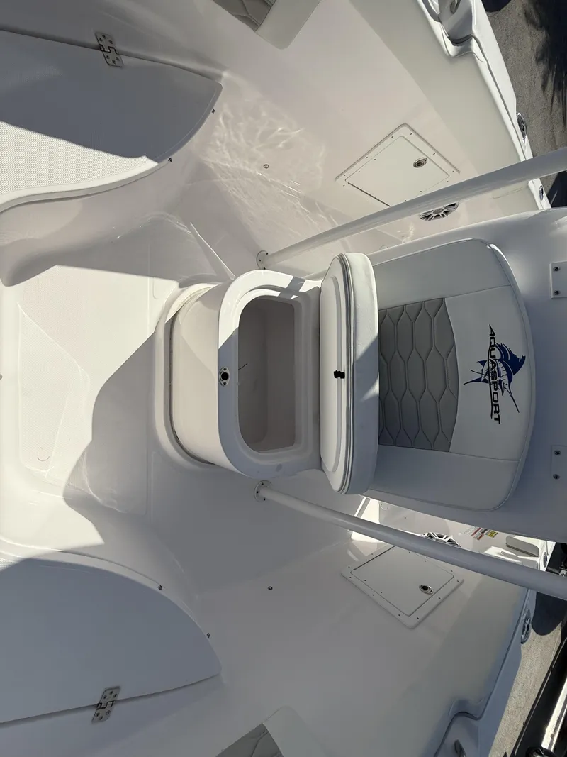 Slide: The Image of 2024 Aquasport 2300 CC boat interior with storage compartment and seating. - 39