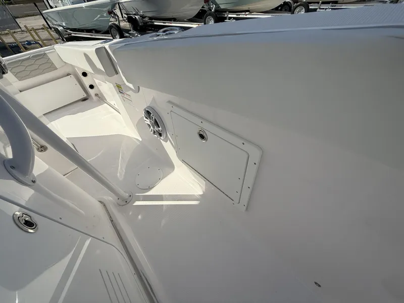 Slide: The Image of 2024 Aquasport 2300 CC boat interior with storage compartment and speaker. - 40