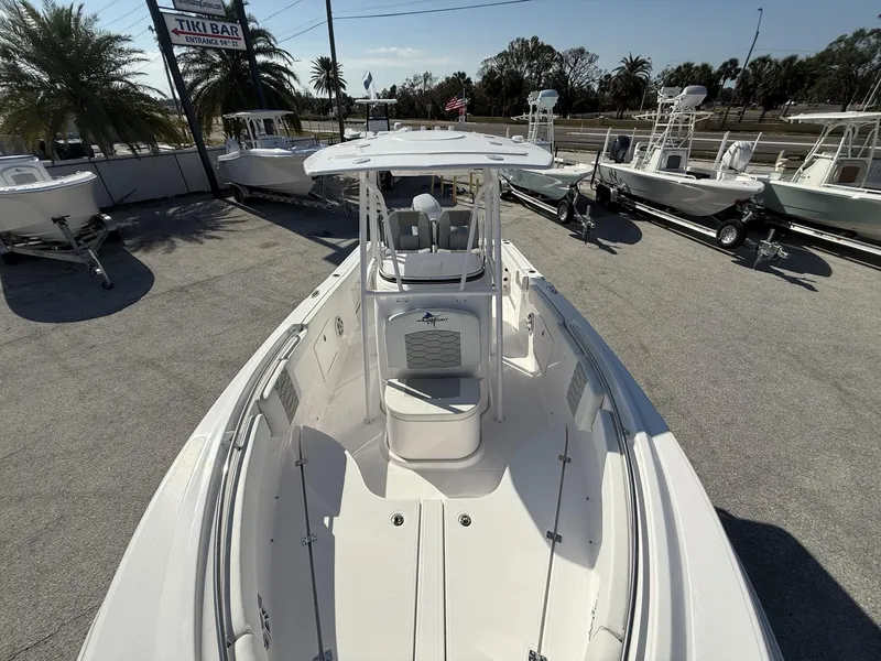 Slide: The Image of 2024 Aquasport 2300 CC boat displayed outdoors with other boats, palm trees, and a Tiki Bar sign. - 9