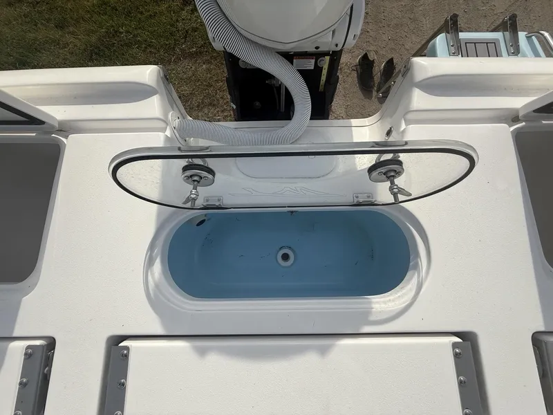Slide: The Image of 2024 Tidewater 2500 Carolina Bay boat with open livewell and hose attachment. - 47